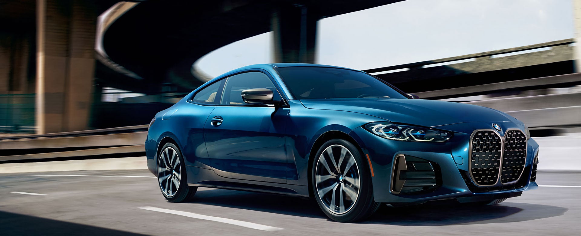 The all-new BMW 4 Series Coupe driving beneath an overpass.