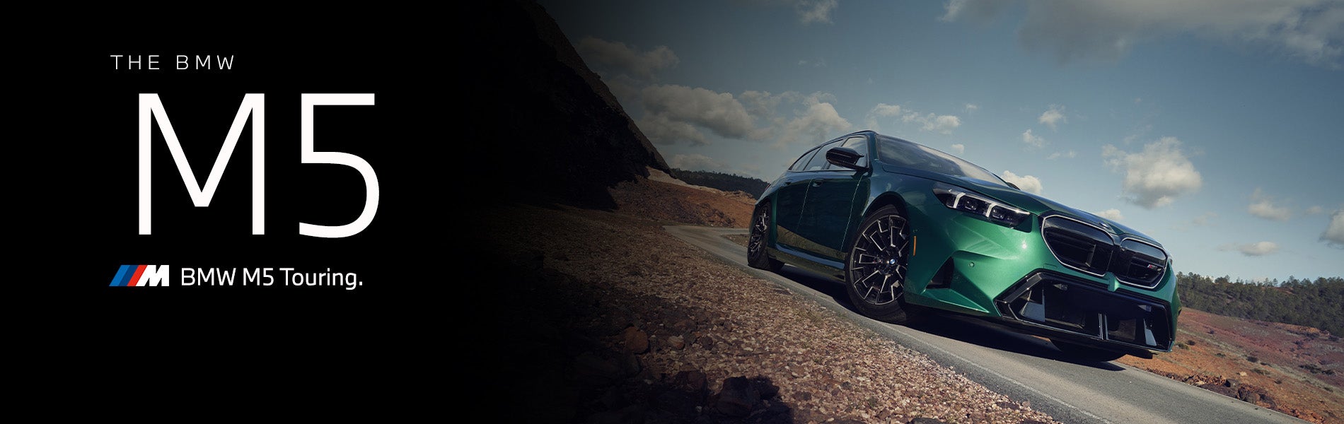 The new BMW M5 Touring in green driving down desert road | BMW of Newton in Newton NJ